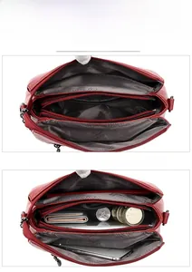 Macro view of red lychee grain leather crossbody bag with three main zipper compartments