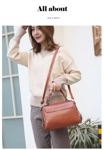 Outdoor shot of a brown crocodile pattern Boston bag with vintage leather handle and strap