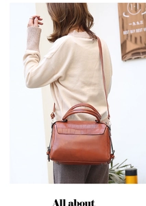 Brown vintage faux leather handbag with crocodile pattern shown on a model's shoulder