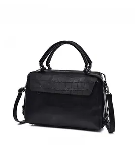 Macro side view of black leather Boston bag with crocodile texture and metal buckle detail