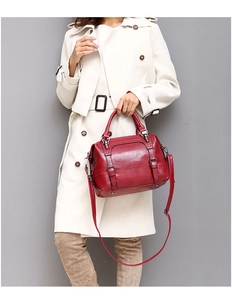 Close-up of a vintage wine red leather doctor bag with adjustable strap and top handles
