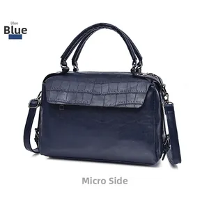 Detail view of the blue crocodile embossed flap and smooth leather texture on women bag