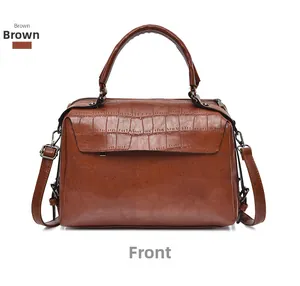 Front view of a brown crocodile pattern Boston bag with top handle and leather texture