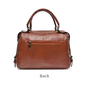 Detail view of the back of a brown wax leather handbag with a functional zipper pocket