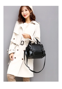 Close-up of black oil wax leather handbag with buckle details and metal studs