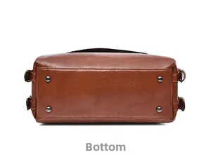 Detailed view of the brown crocodile-pattern bag bottom with four protective metal studs