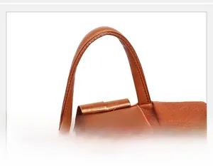 Detailed close-up of brown faux leather handbag strap with neat stitching and lychee texture