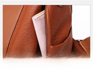 Detailed view of the side zipper pocket on a brown lychee-patterned leather backpack