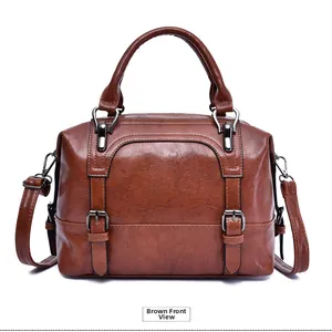 Front detail of brown vintage faux leather boston bag with dark metallic buckles