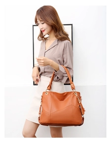 Dettaglio della borsa shopper marrone arancio in pelle martellata con nappa decorativa