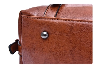 Macro detail of brown oil wax leather bag bottom with silver protective metal studs