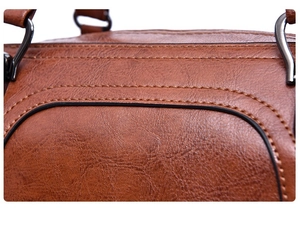 Close-up of brown oil wax leather texture with double stitching and gunmetal hardware