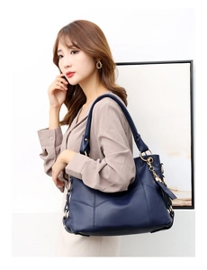 Dettaglio della borsa tote in pelle blu scuro con trama litchi e metallo dorato