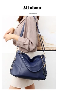 Dettaglio della borsa tote in pelle martellata blu scuro con catena dorata e modella