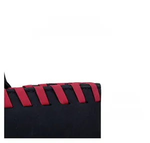 Détail d'un sac à main noir givré avec contraste de bandoulière tressée rouge