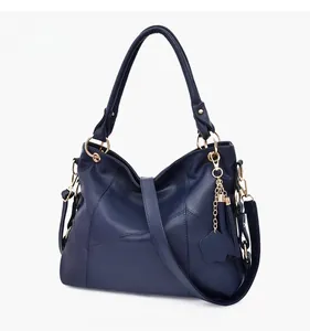 Dettaglio borsa shopper blu scuro con motivo litchi, ciondolo a stella e tracolla rimovibile
