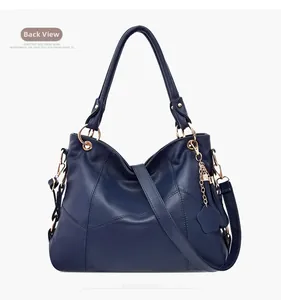 Dettaglio della borsa blu navy in pelle a grana di litchi con finiture in oro