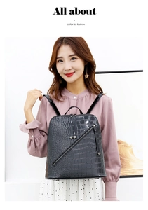 Close-up of black crocodile pattern leather backpack featuring sleek metal zipper detail