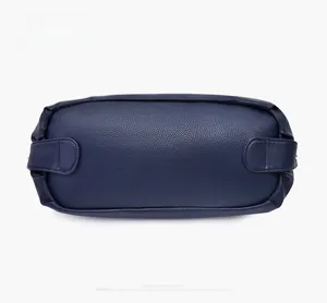 Dettaglio del fondo della borsa in pelle martellata blu scuro con cuciture rinforzate