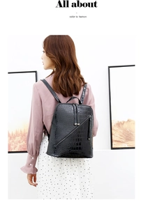 Rear view of a model wearing a black faux crocodile leather backpack with metal zipper