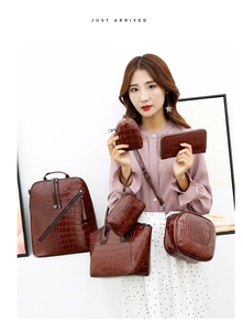 Detail of dark brown crocodile-embossed 6-piece bag set including tote and backpack