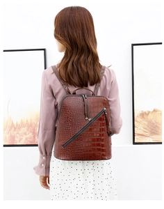 Brown crocodile embossed PU leather backpack with diagonal zipper shown on a model