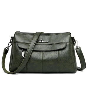 Dark green faux leather crossbody bag with adjustable strap and metal logo on white background
