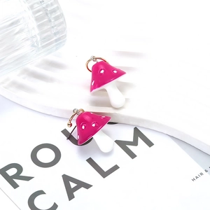 Chic pink mushroom dangle earrings with gold hooks on a minimalist white display