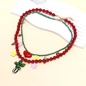 Détail du collier à perles superposées avec pendentifs cactus en émail et cœur