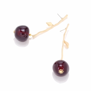 Close-up of resin cherry earrings with golden stems and polished red fruit finish