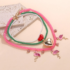 Détails d'un collier multicouche avec pendentif flamant rose, cœurs émail et perles
