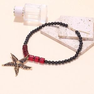 Detail of beaded sea star pendant necklace with gold lobster clasp and extension chain