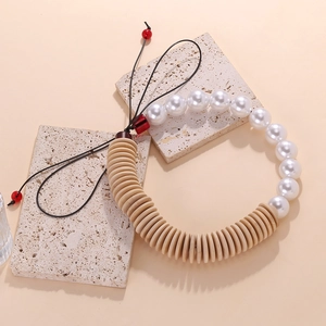 Detail of beaded necklace with faux pearls, natural wood discs, and adjustable red cord