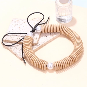 Collier artisanal en perles de bois avec disques géométriques et grandes perles nacrées