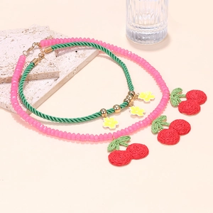 Detail of woven cherry pendants and floral bead necklaces with gold lobster clasps