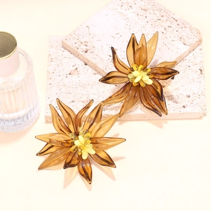 Macro detail of handmade beaded jelly flower earrings with amber resin petals and yellow core