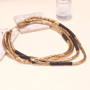 Exaggerated multi-layer beaded necklace with gold metal tubes and black textured segments