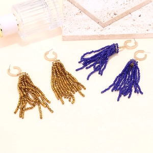 Detail of long crystal tassel earrings with C-shaped gold clasps in gold and blue