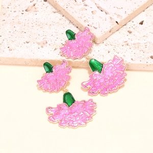 Detailed close-up of pink enamel carnation earrings with gold trim on stone background