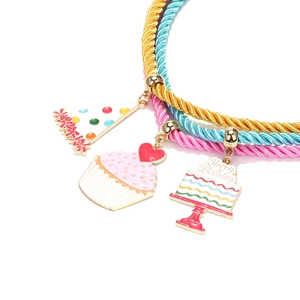 Detailed close-up of three colorful cord necklaces with festive birthday themed charms