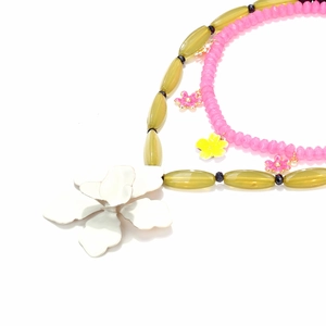 Dettaglio macro della collana di perline multistrato con grandi fiori pendenti in resina