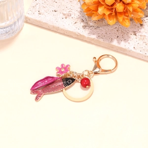 Détail du porte-clés poisson tropical en émail rose avec breloque fleurie et fermoir doré