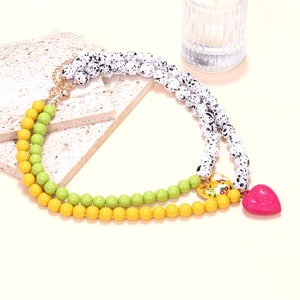 Close-up of double-layer beaded necklace with colorful enamel heart pendants
