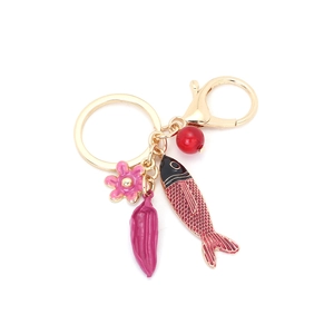 Porte-clés poisson tropical et fleur en émail doré sur fond blanc pur et net