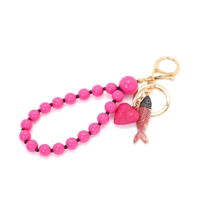 Pink beaded keychain with colorful enamel fish and embossed heart charms on gold ring
