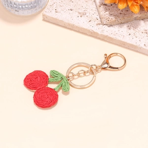 Handmade crochet cherry keychain with red fruit, green leaves, and gold lobster clasp