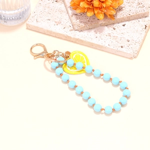Handmade beaded keychain featuring light blue beads and a yellow lemon slice charm pendant
