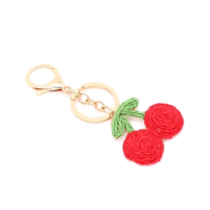 Handmade woven cherry keychain with red yarn fruits, green leaves, and golden metal clasp