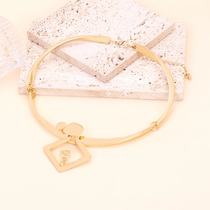 Collier ras de cou doré avec pendentif géométrique et détails ronds sur fond pierre