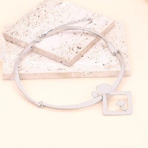 Détail du collier ras de cou argenté avec pendentifs géométriques carrés et ronds